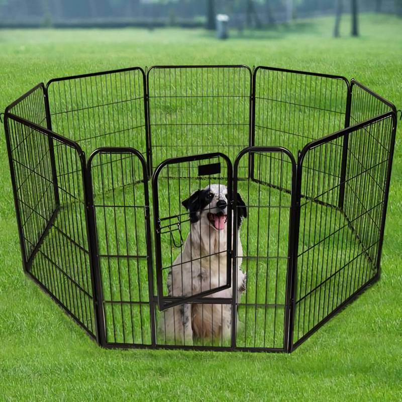 A dog is sitting on the grassland and enclosed by the exercise pen.